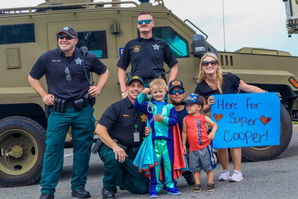 Wish Kid Super Cooper poses with first responders after saving the day!