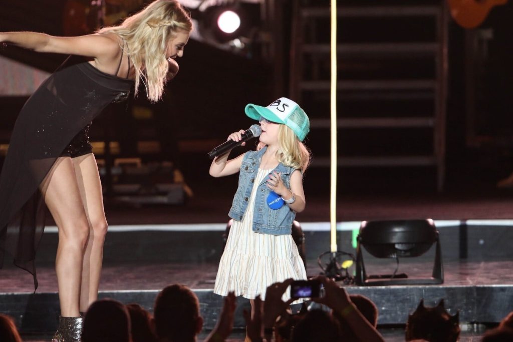 Wish Kid Holin singing on stage with Kelsea Ballerini
