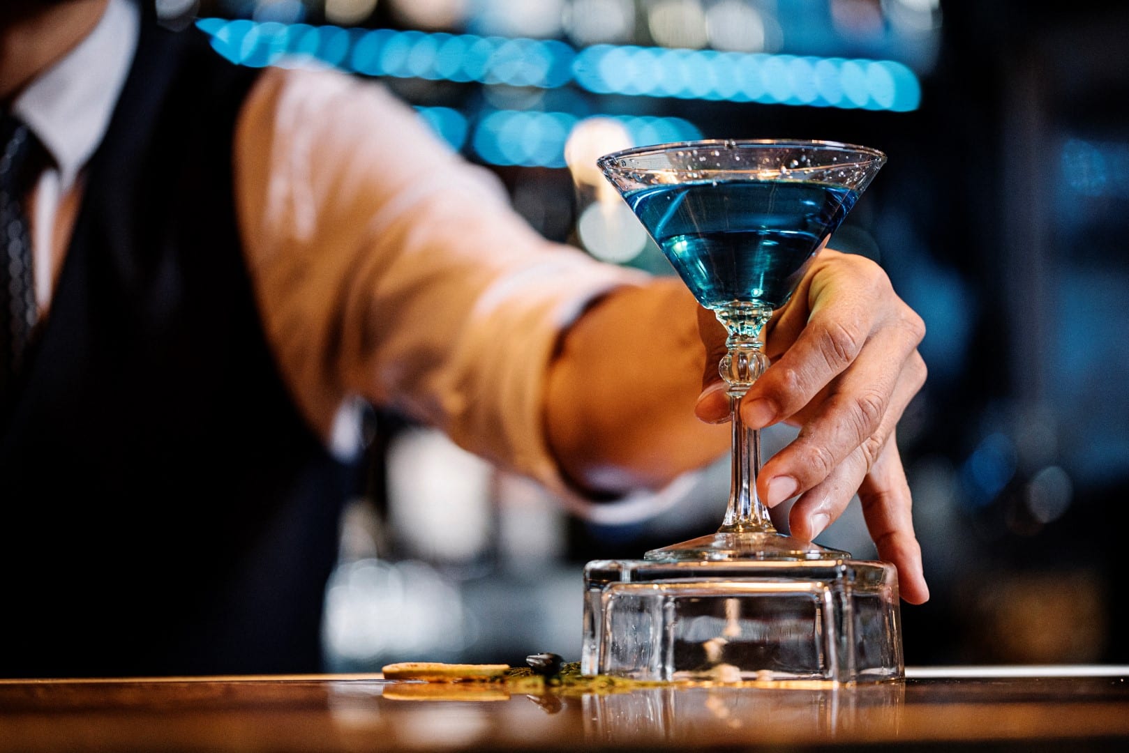 bartender serving up blue cocktail