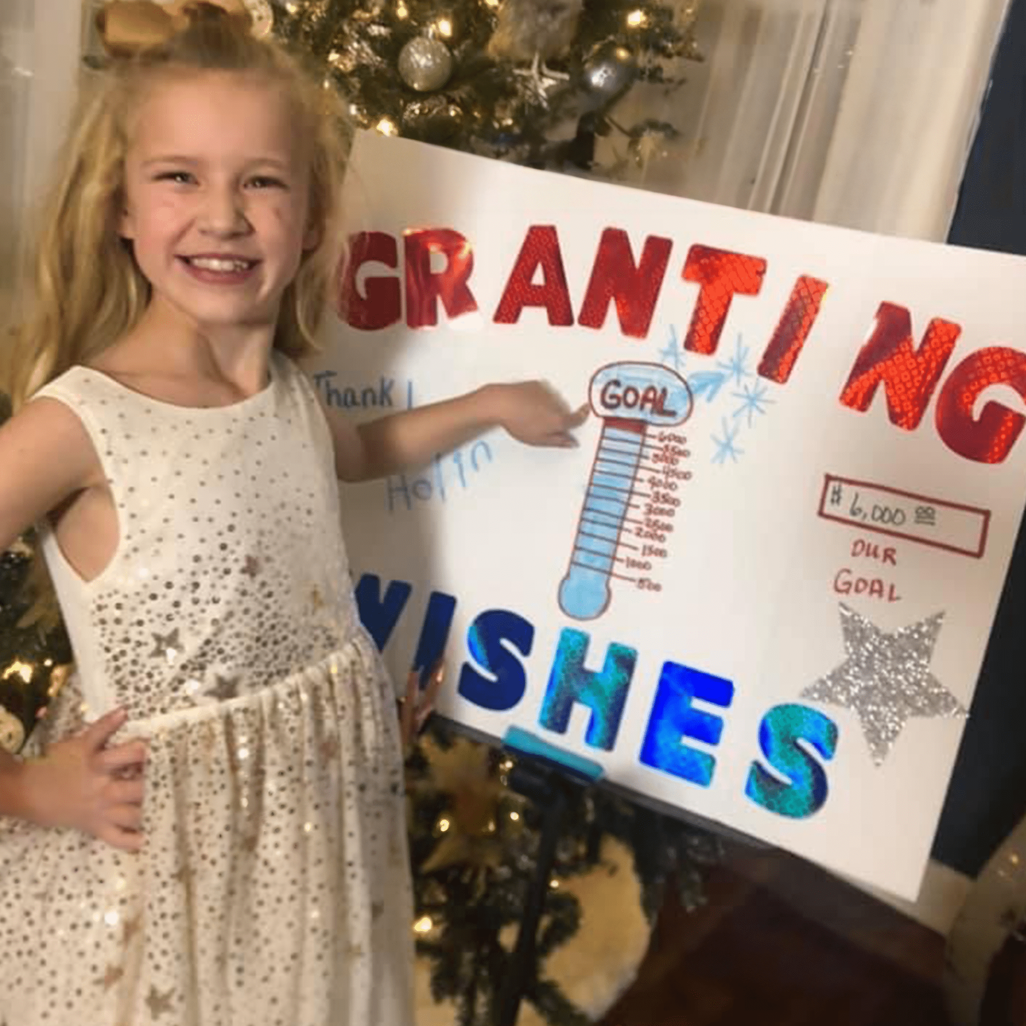 Wish kid Holin next to fundraiser poster