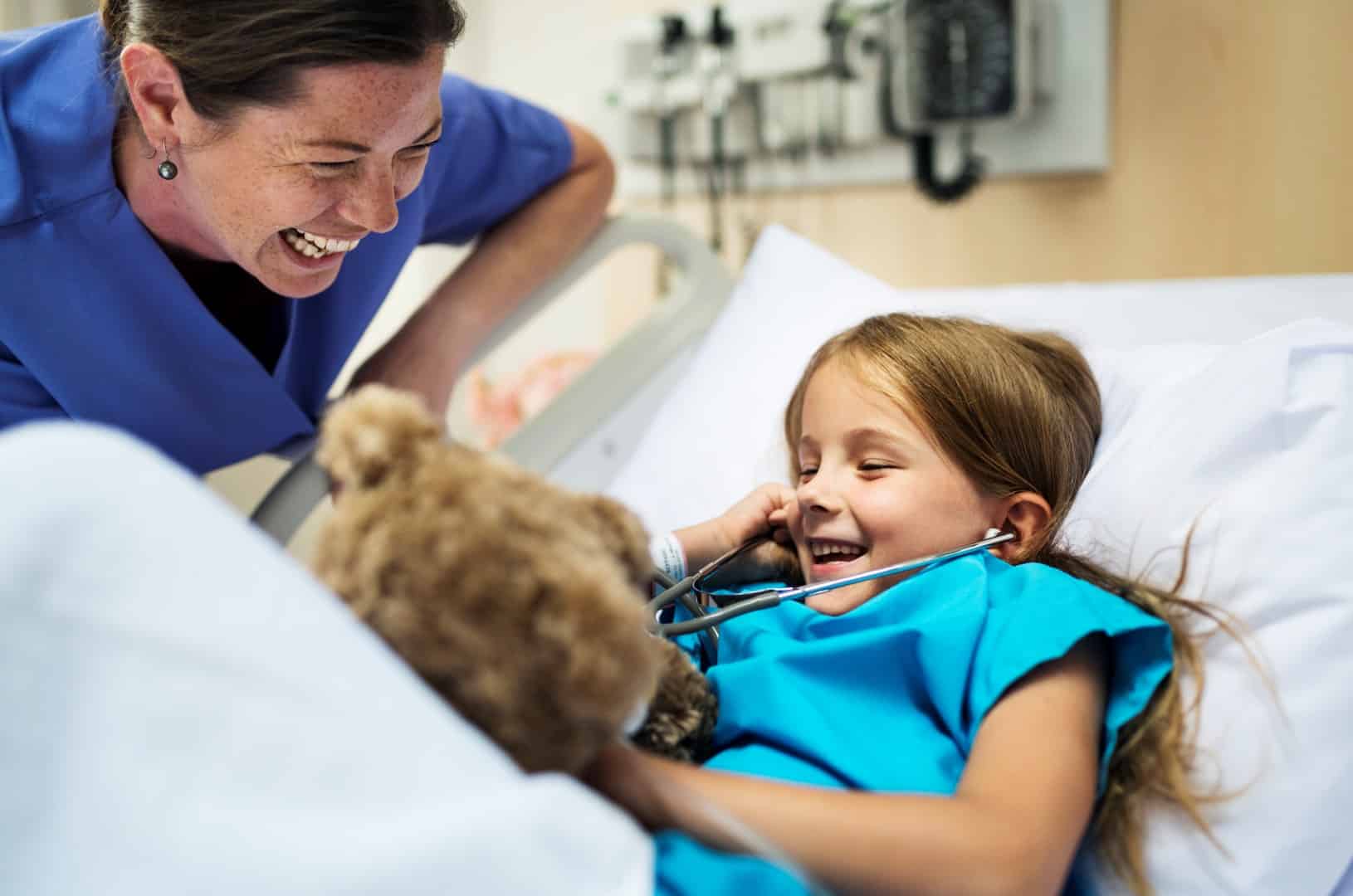 Young patient laughing with doctor in hospital